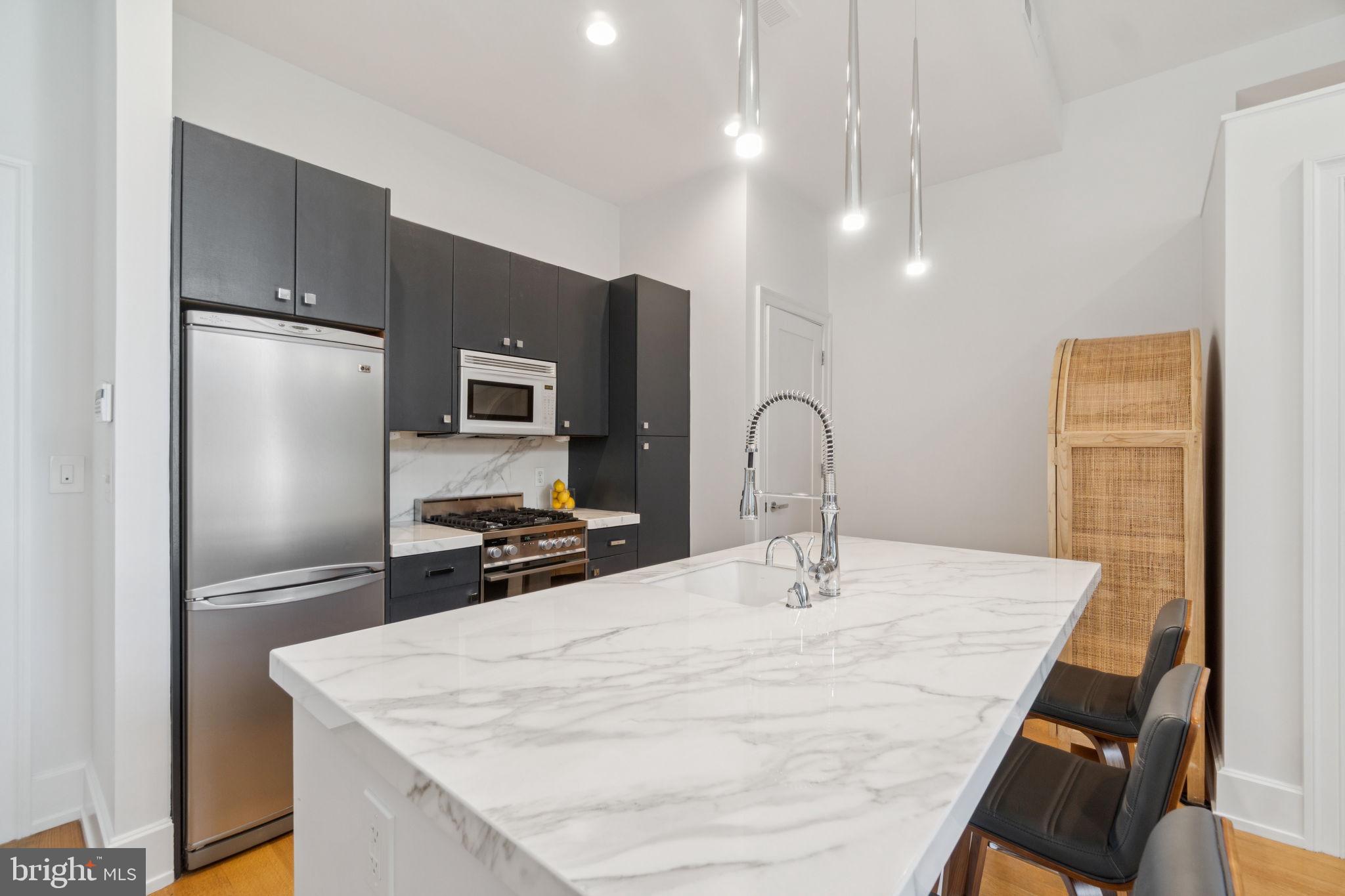 2516 Q Street Northwest, Unit Q206 Washington, DC 20007 - Photo 4 of 16 a kitchen with kitchen island a sink appliances and a counter top space