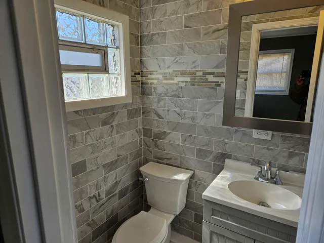 a bathroom with a toilet sink and mirror