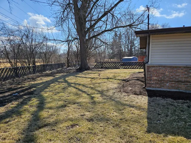 a view of a yard with wooden fence