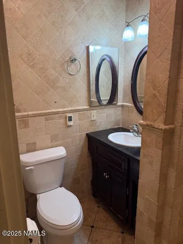 a bathroom with a toilet sink vanity and mirror