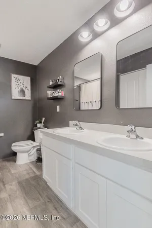 a bathroom with a toilet a sink and mirror