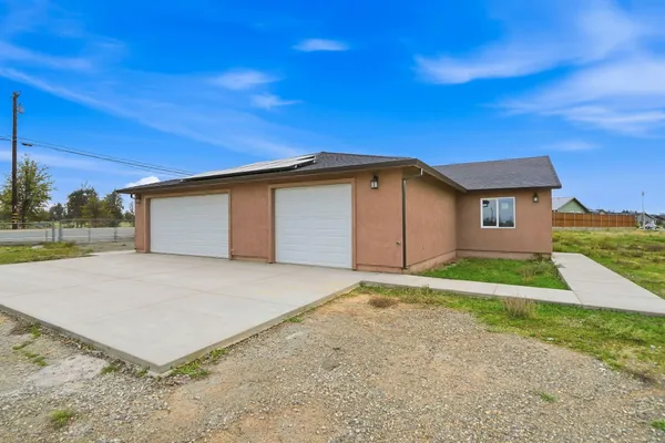 a view of an empty room with a ceiling fan and wooden floor