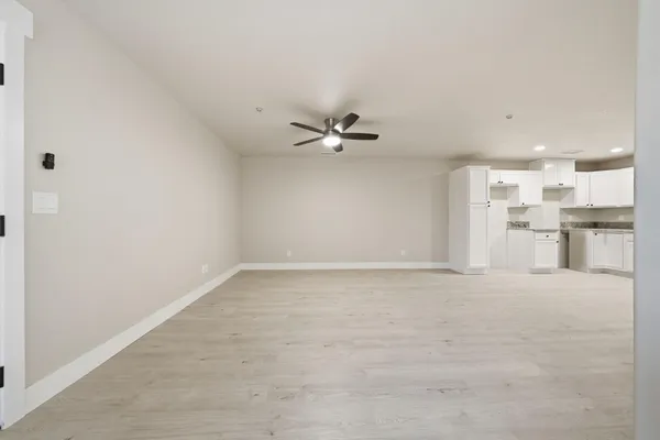 a large white kitchen with a sink and cabinets