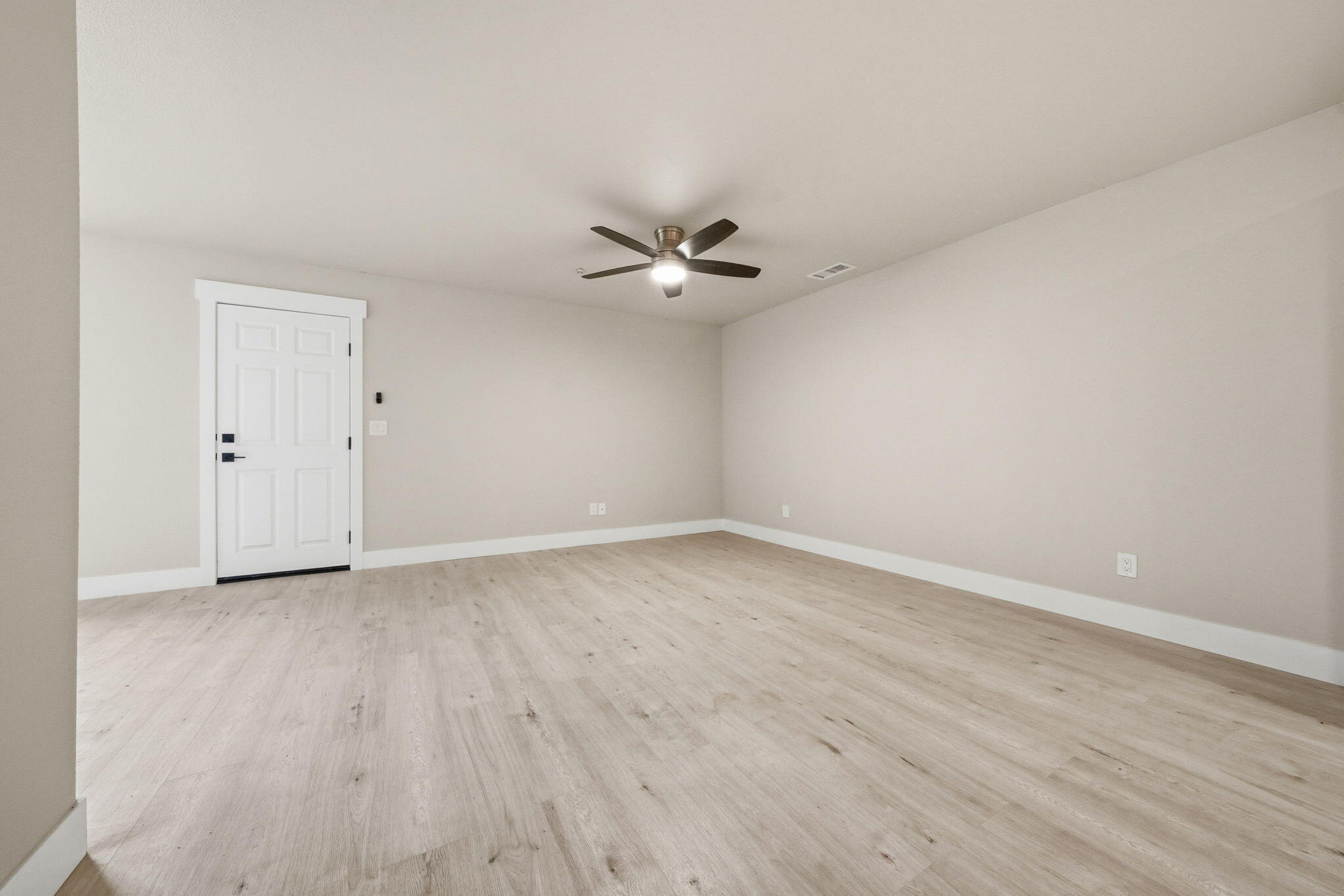 17014 Keswick Dam Road Redding, CA 96003 - Photo 27 of 61 a view of an empty room with a ceiling fan and wooden floor