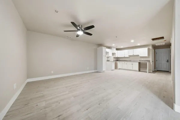 an empty room with a window and ceiling fan