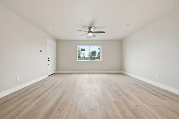 a view of an empty room with wooden floor