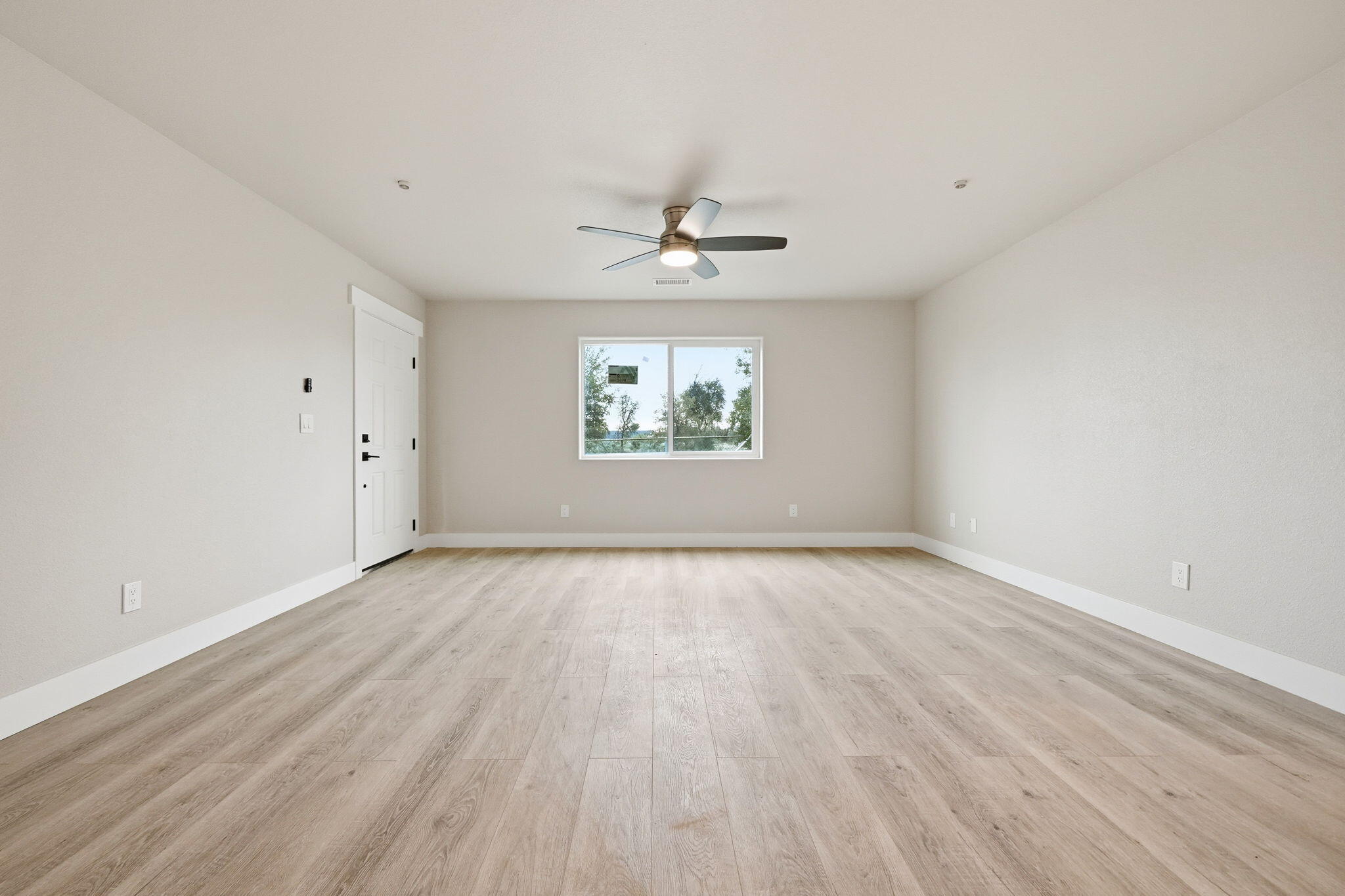 17014 Keswick Dam Road Redding, CA 96003 - Photo 10 of 61 an empty room with wooden floor chandelier fan and windows