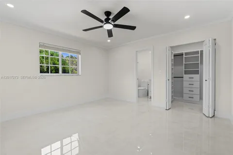 an empty room with a window and a ceiling fan