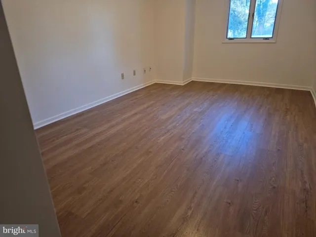 a view of a room that has wooden floor and large window