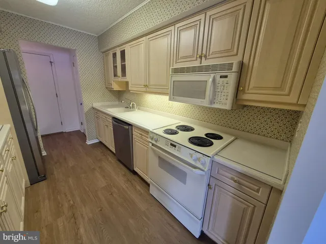 a kitchen with granite countertop a sink a stove and refrigerator
