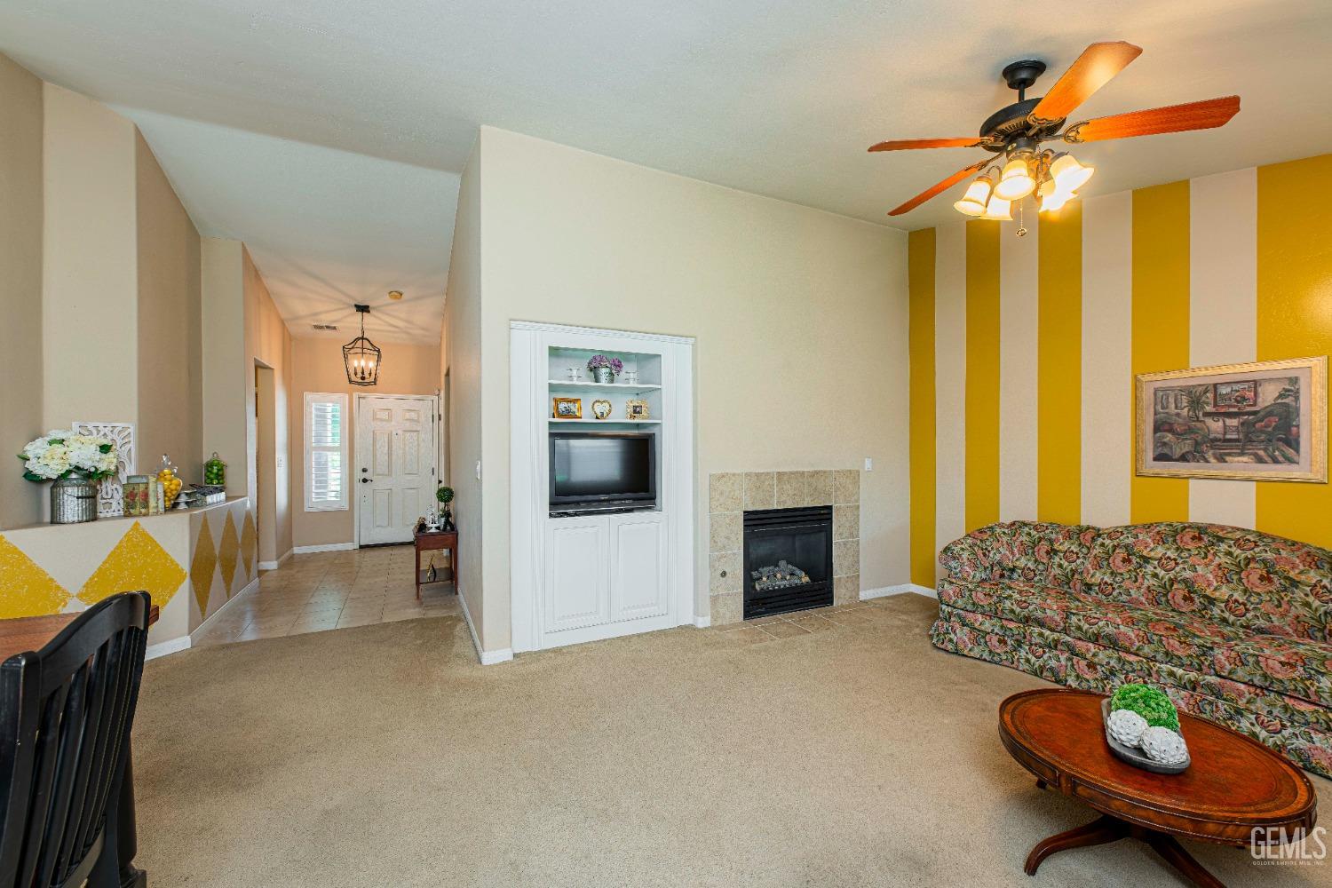Undisclosed Address Bakersfield, CA 93312 - Photo 12 of 41 a living room with furniture a fireplace and a chandelier