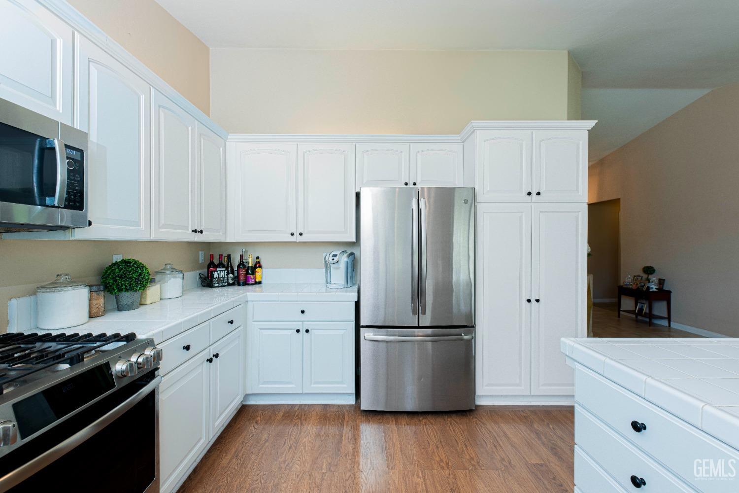 Undisclosed Address Bakersfield, CA 93312 - Photo 18 of 41 a kitchen with a refrigerator and white cabinets