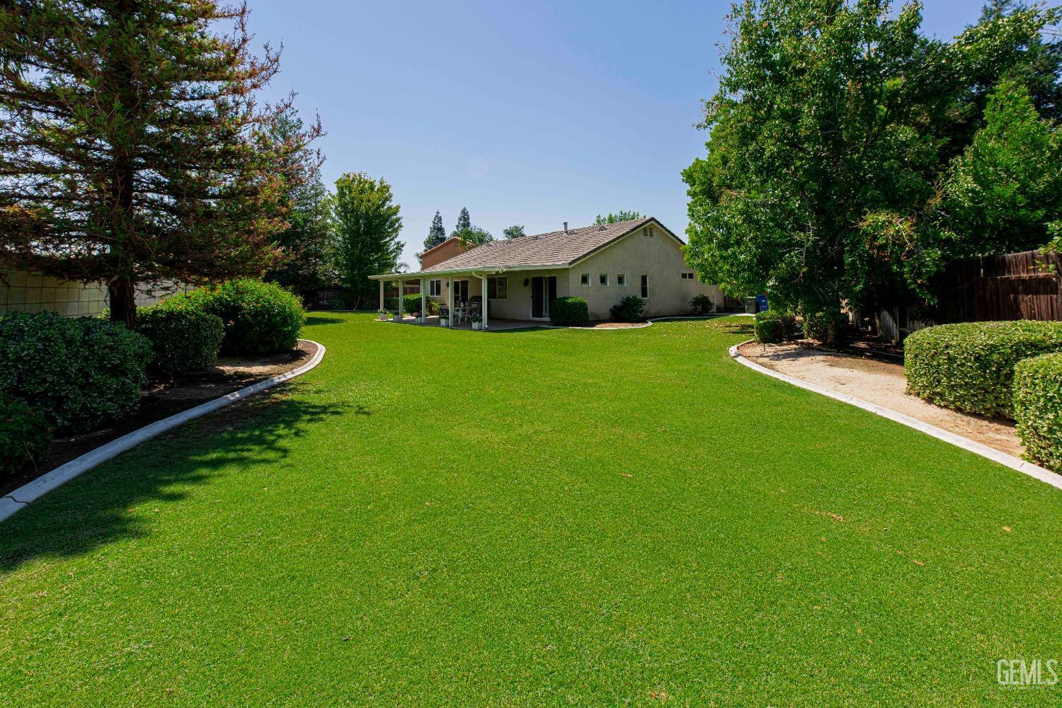 Undisclosed Address Bakersfield, CA 93312 - Photo 34 of 41 a view of a garden with a house in the background