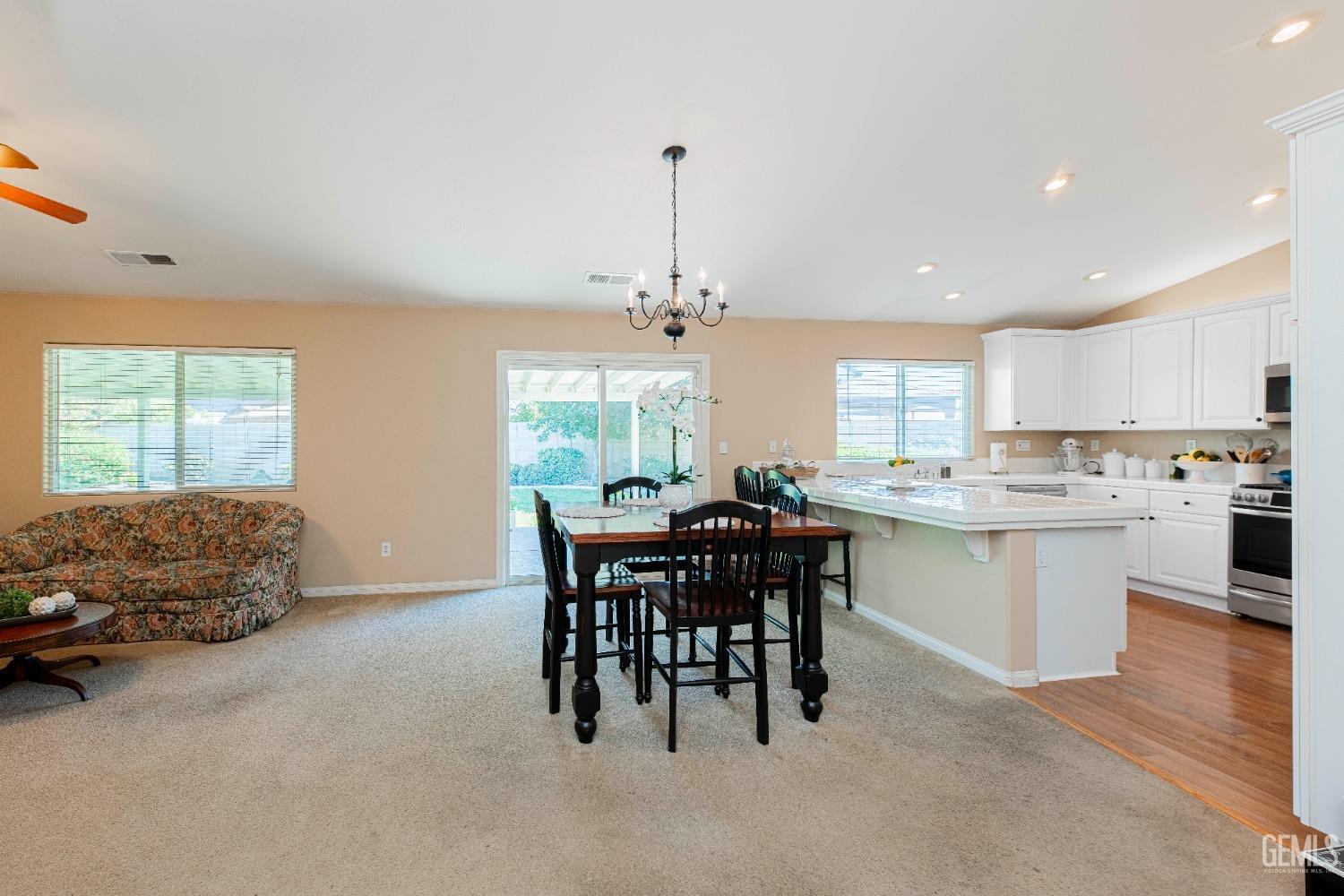 Undisclosed Address Bakersfield, CA 93312 - Photo 9 of 41 a kitchen with stainless steel appliances kitchen island granite countertop a table chairs sink and cabinets