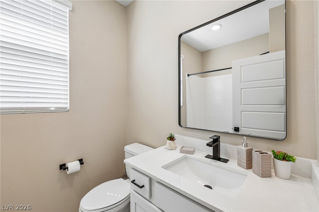 194 Viento Ridge Street Henderson, NV 89012 - Photo 48 of 72 A modern vanity with a sleek white countertop sits beneath a large rectangular mirror.