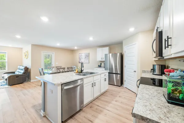 a kitchen with stainless steel appliances granite countertop a sink stove and refrigerator