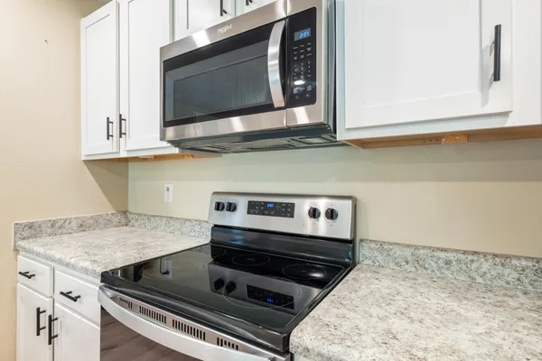a kitchen with granite countertop a sink and a refrigerator