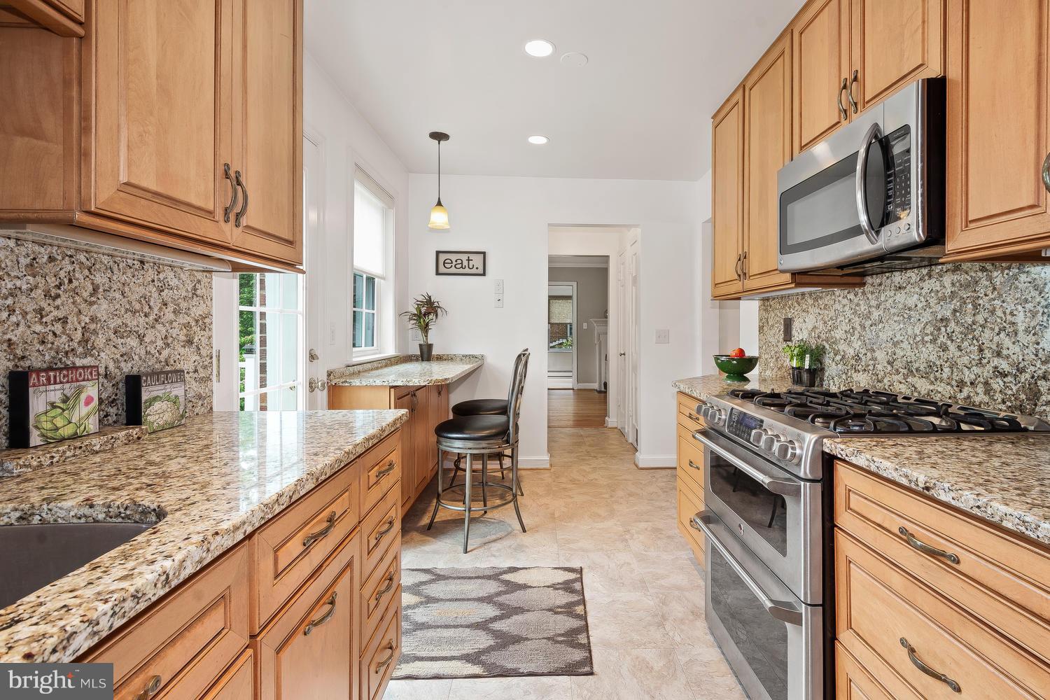 9505 St Andrews Way Silver Spring, MD 20901 - Photo 12 of 30 a kitchen with stainless steel appliances granite countertop a stove top oven a sink dishwasher and a microwave oven with white cabinets
