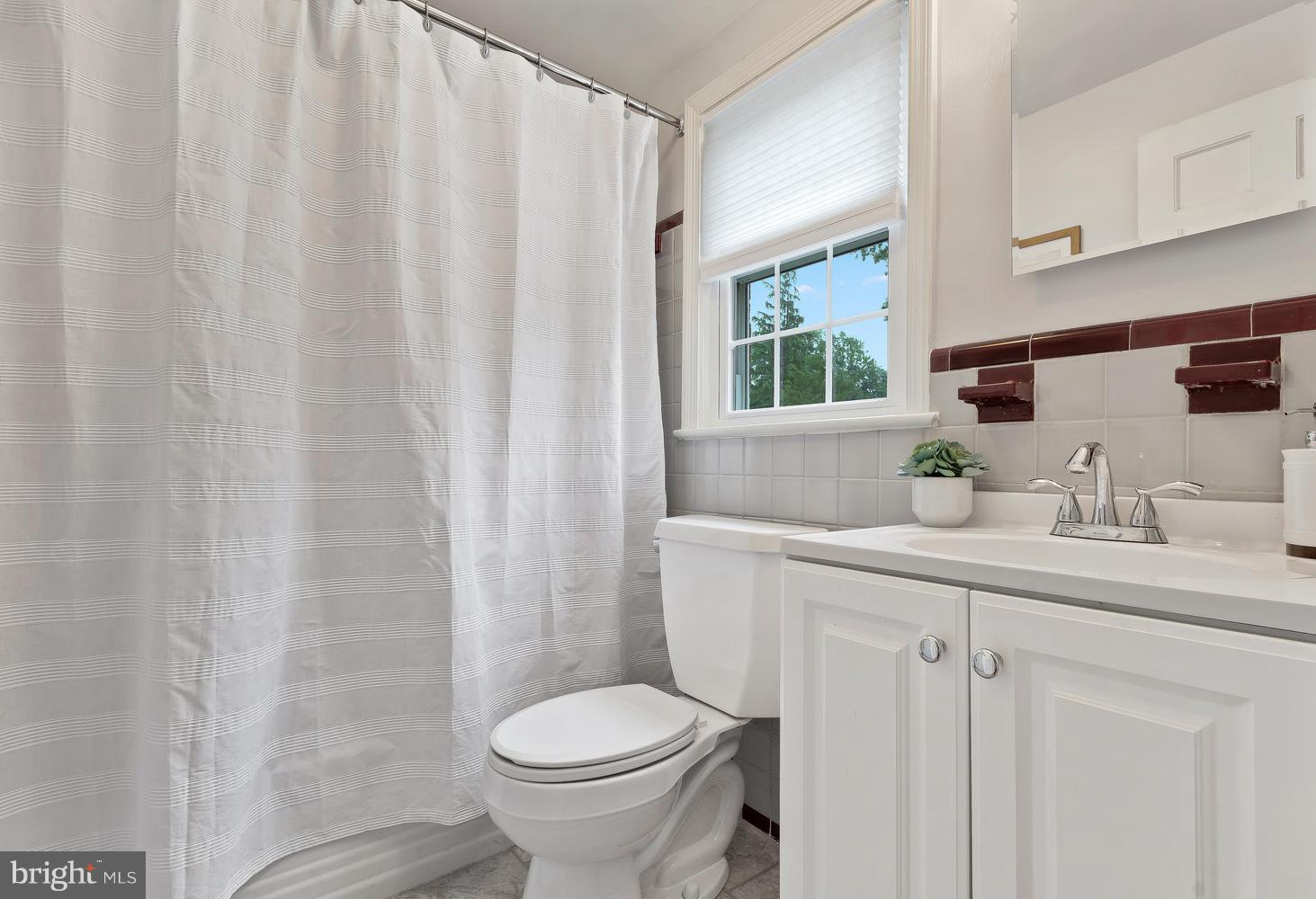 9505 St Andrews Way Silver Spring, MD 20901 - Photo 17 of 30 a bathroom with a sink a toilet and a mirror