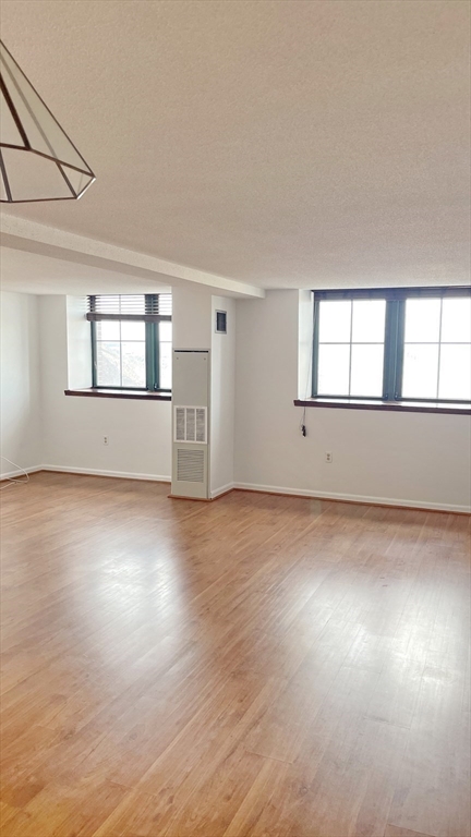200 Market Street, Unit 505 Lowell, MA 01852 - Photo 14 of 22 an empty room with wooden floor and windows
