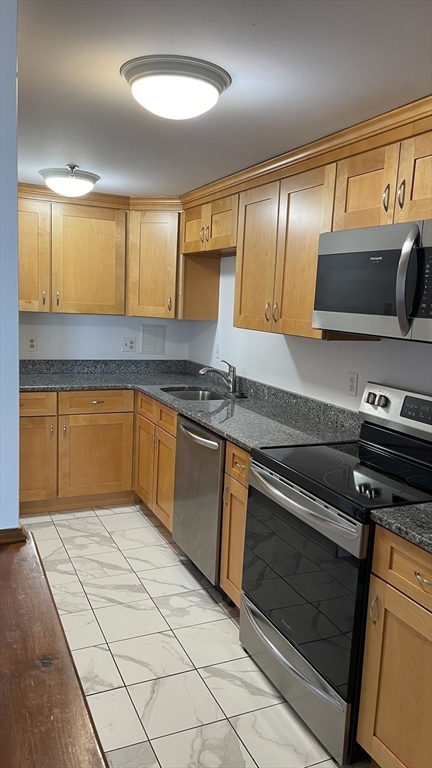 200 Market Street, Unit 505 Lowell, MA 01852 - Photo 16 of 22 a kitchen with stainless steel appliances granite countertop a sink and a stove