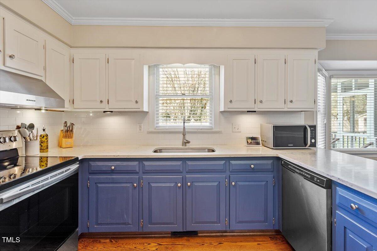 8617 Canoe Court Raleigh, NC 27615 - Photo 13 of 40 a kitchen with granite countertop wooden cabinets stainless steel appliances a sink and a window
