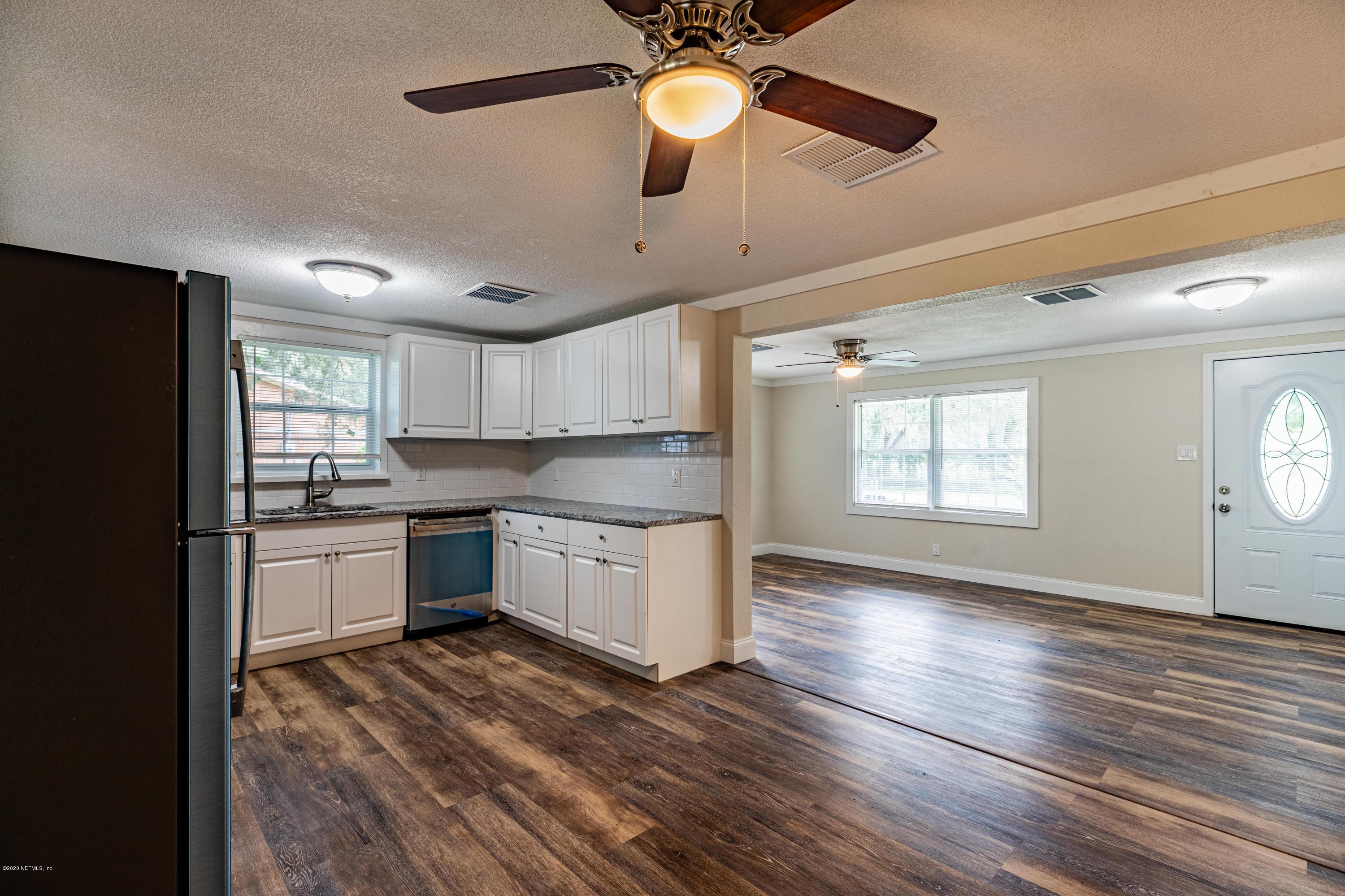 620 Southwest Field Avenue Keystone Heights, FL 32656 - Photo 15 of 68 a kitchen with granite countertop a stove cabinets and wooden floor