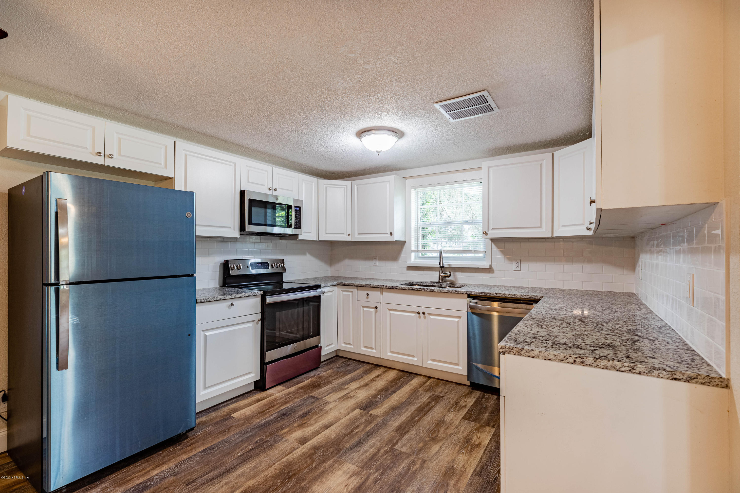 620 Southwest Field Avenue Keystone Heights, FL 32656 - Photo 16 of 68 a kitchen with granite countertop stainless steel appliances a refrigerator a stove top oven a sink and dishwasher