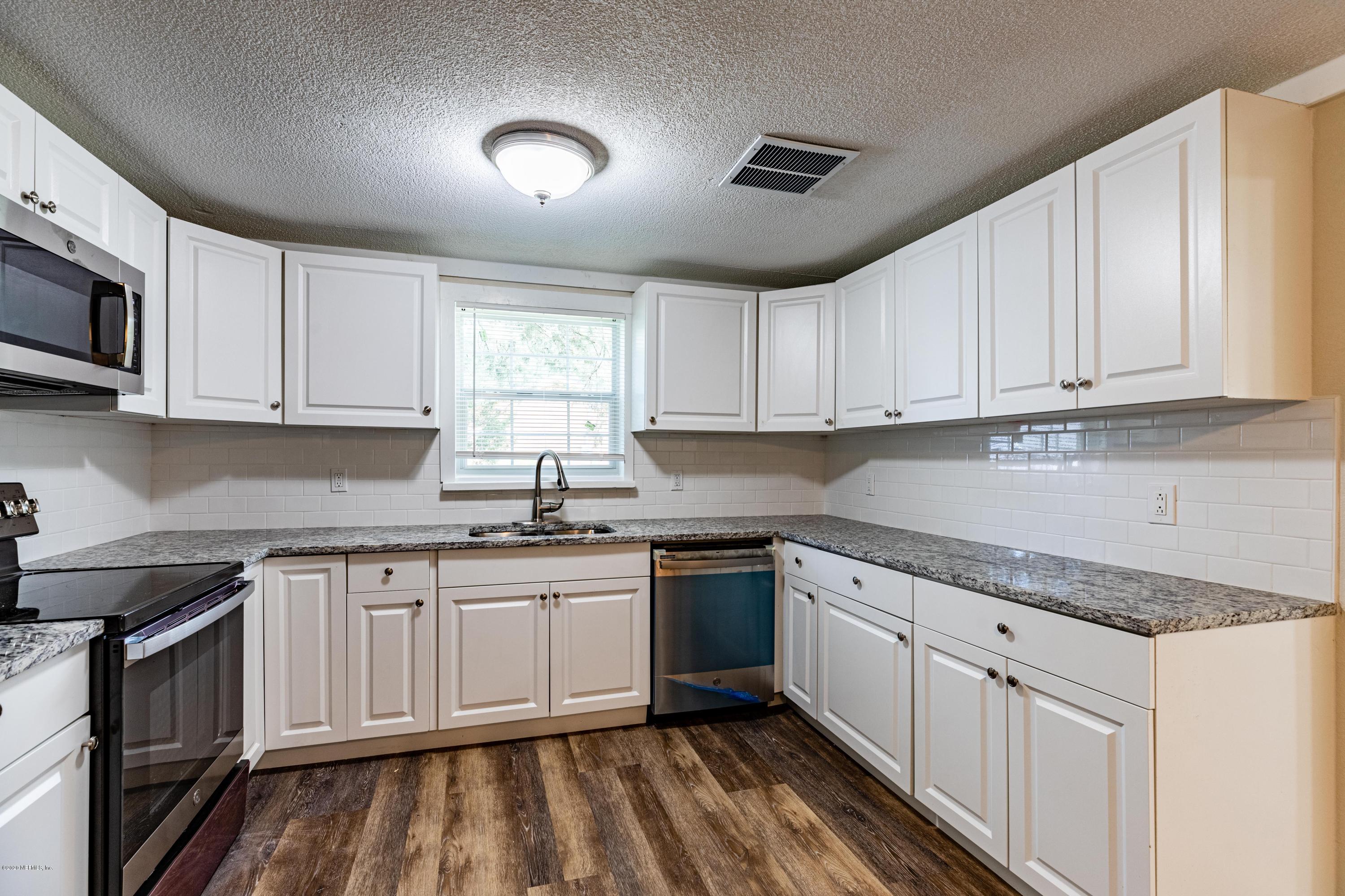 620 Southwest Field Avenue Keystone Heights, FL 32656 - Photo 17 of 68 a kitchen with white cabinets appliances and sink