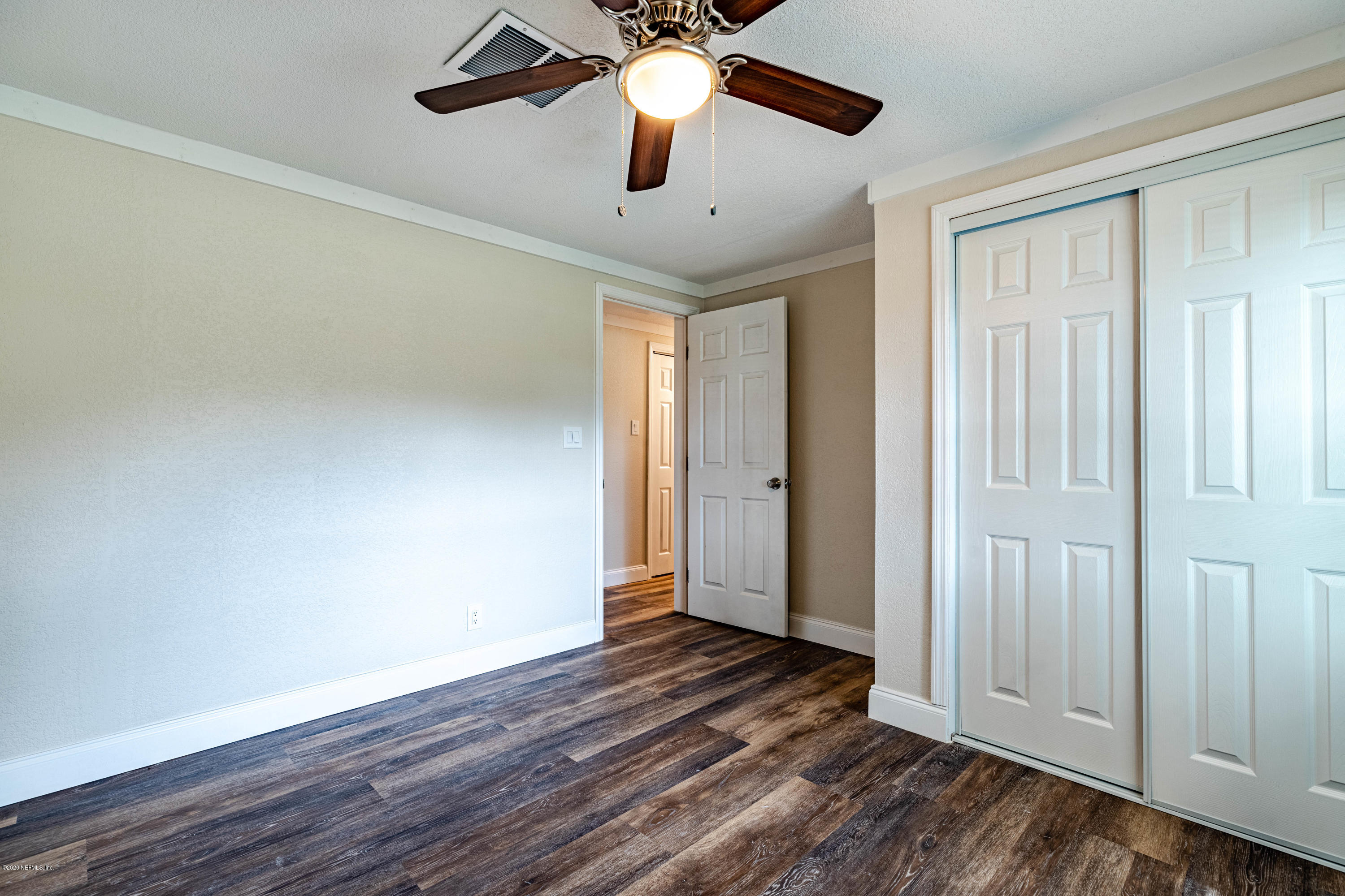 620 Southwest Field Avenue Keystone Heights, FL 32656 - Photo 27 of 68 an empty room with wooden floor chandelier fan and windows