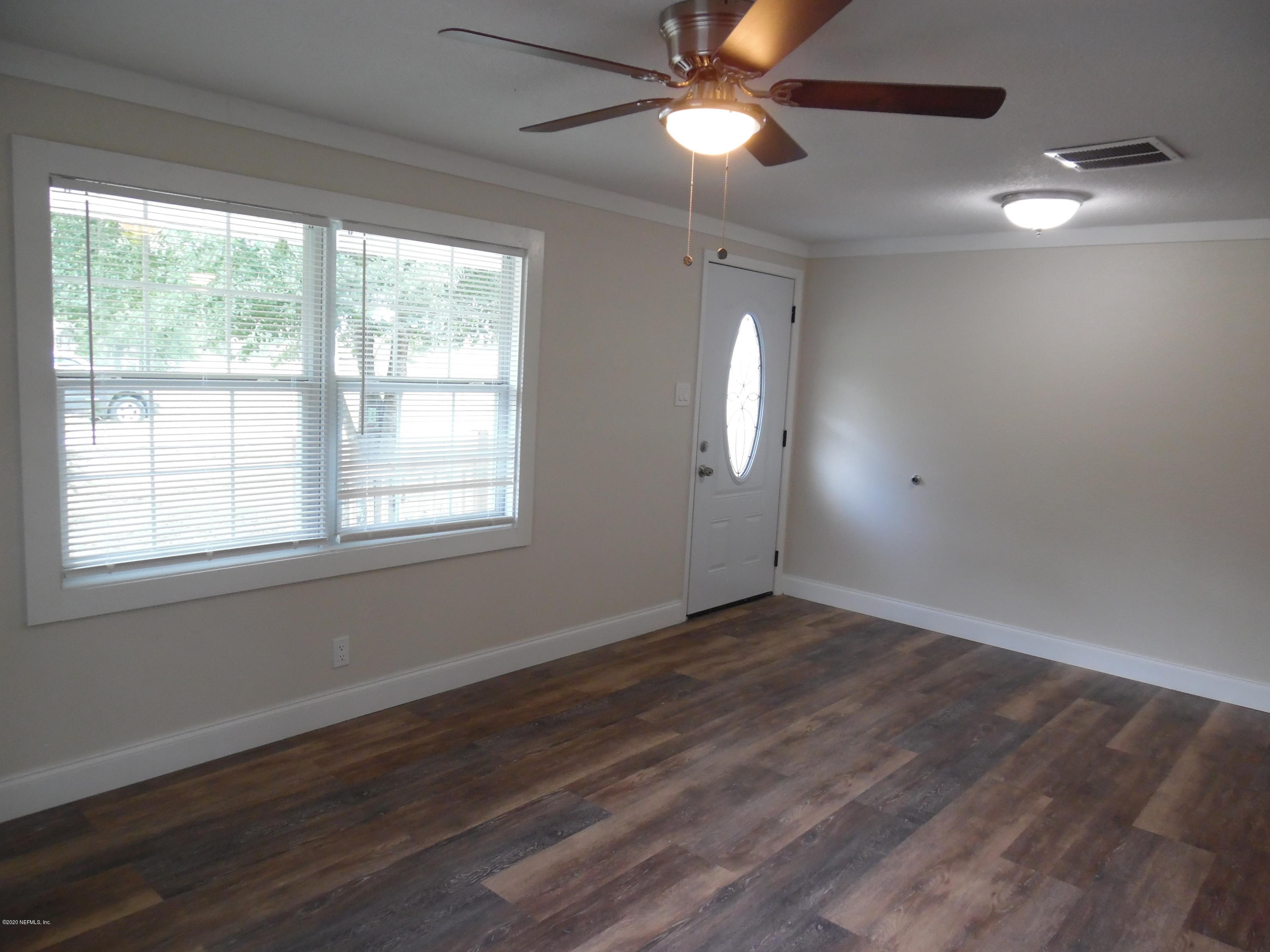 620 Southwest Field Avenue Keystone Heights, FL 32656 - Photo 41 of 68 an empty room with wooden floor fan and windows