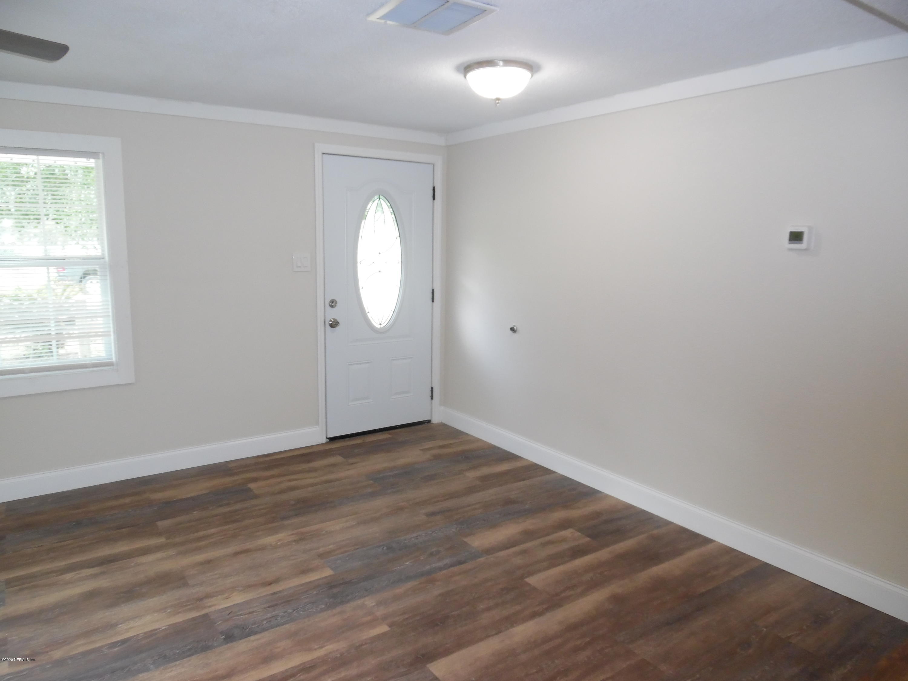 620 Southwest Field Avenue Keystone Heights, FL 32656 - Photo 42 of 68 an empty room with wooden floor and windows