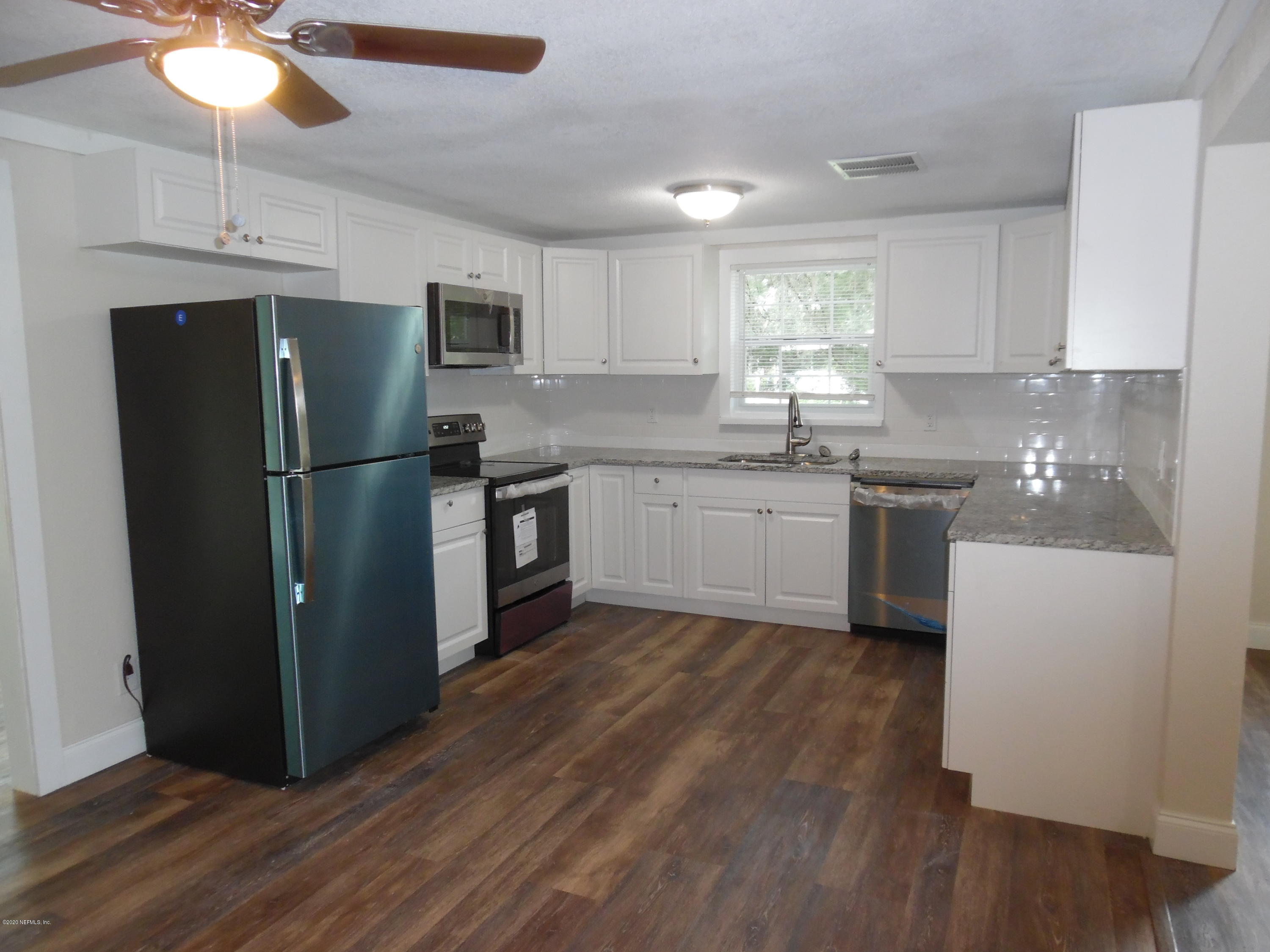 620 Southwest Field Avenue Keystone Heights, FL 32656 - Photo 44 of 68 a kitchen with stainless steel appliances granite countertop a refrigerator a sink dishwasher a stove top oven a dining table and chairs with wooden floor