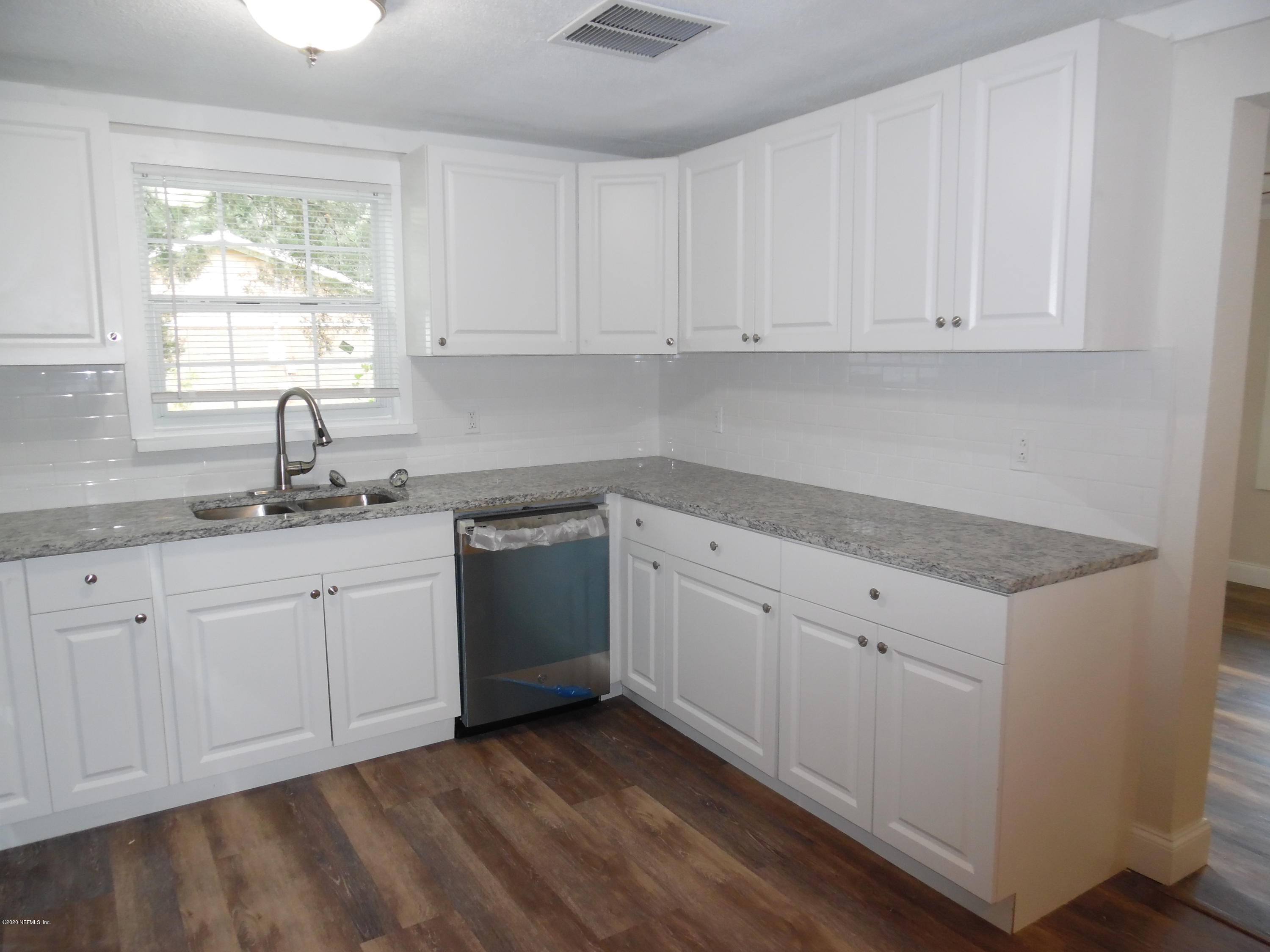 620 Southwest Field Avenue Keystone Heights, FL 32656 - Photo 45 of 68 a kitchen with granite countertop white cabinets white appliances a sink and a window