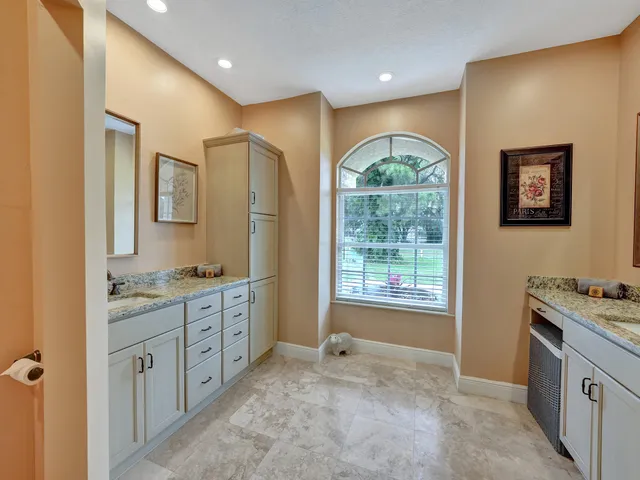 a bathroom with a granite countertop sink a vanity a window and a mirror