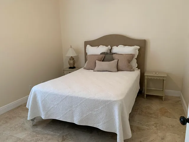 a large bed sitting in a bedroom next to a window