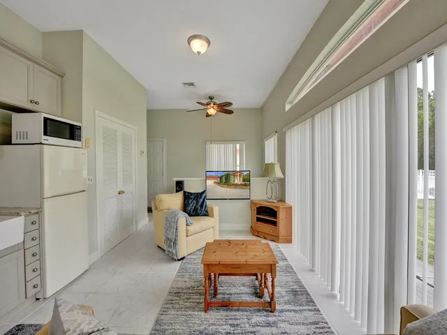 a living room with furniture a rug and white walls