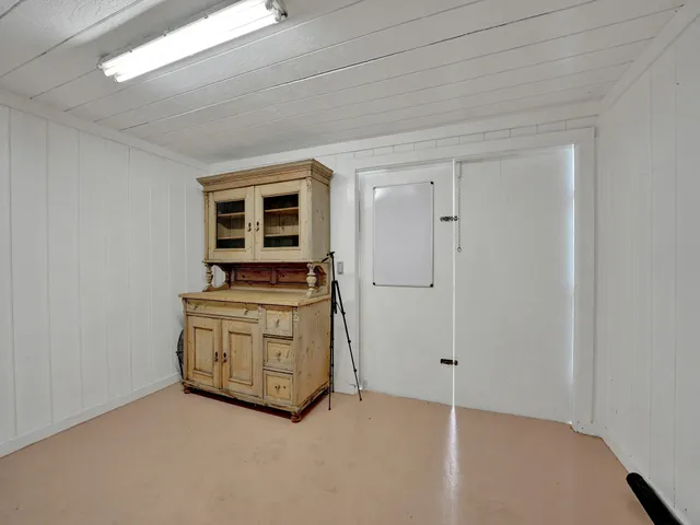 a view of an empty room with cabinet and a window