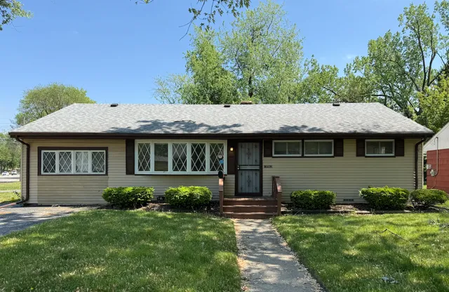 a view of a house with backyard and garden