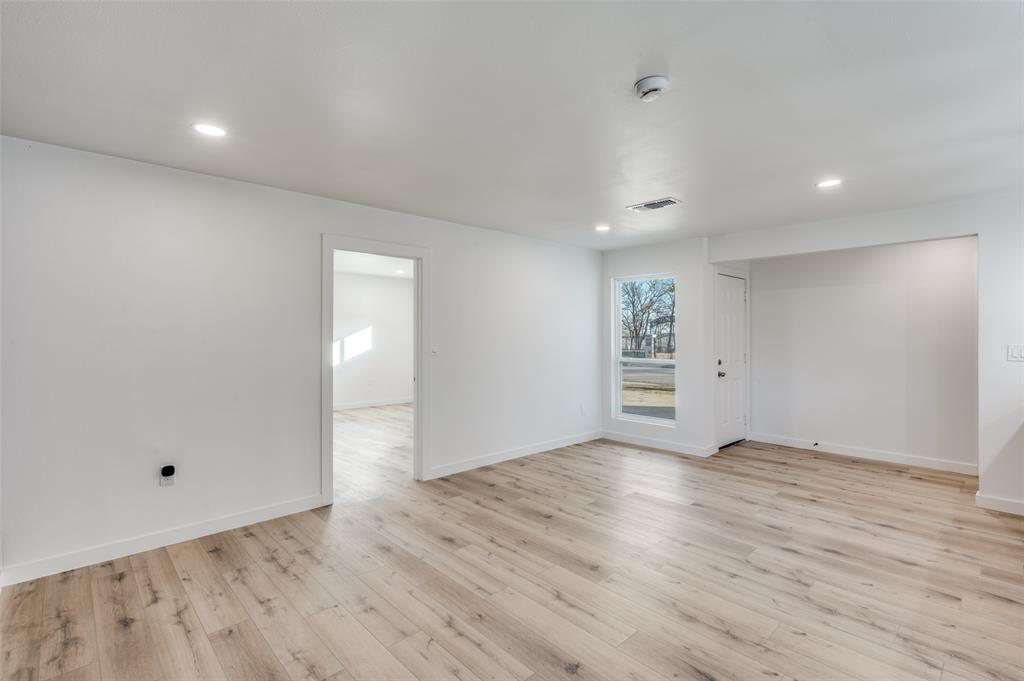 116 Cooper Drive Hurst, TX 76053 - Photo 4 of 25 a view of an empty room with wooden floor and windows
