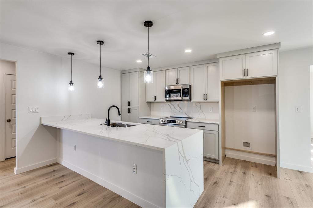 116 Cooper Drive Hurst, TX 76053 - Photo 8 of 25 a kitchen with stainless steel appliances kitchen island a sink a stove a refrigerator and cabinets