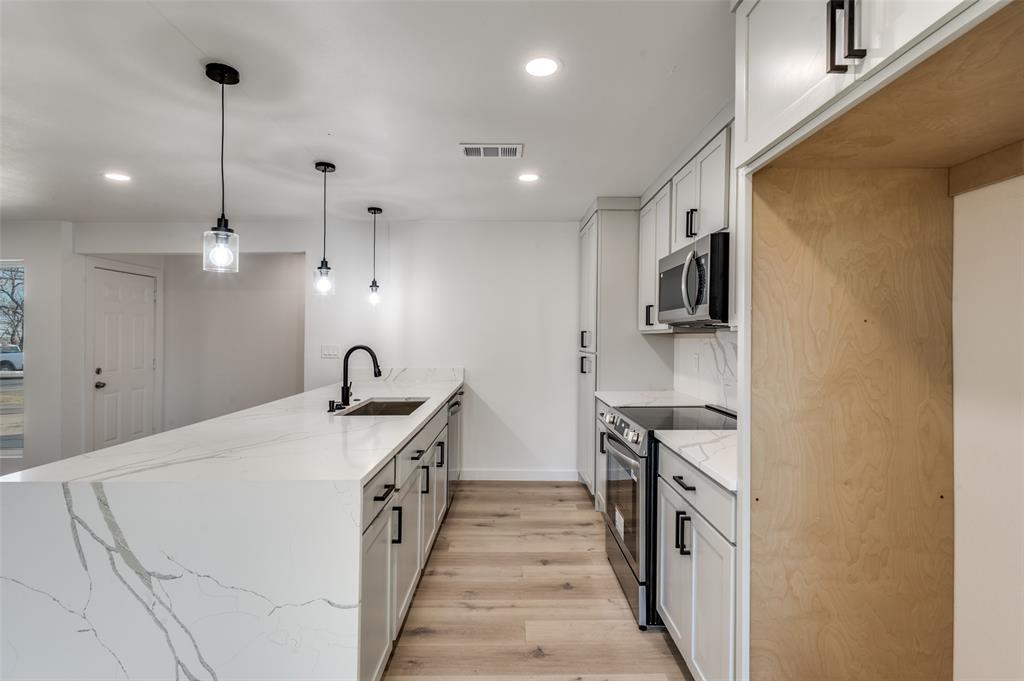 116 Cooper Drive Hurst, TX 76053 - Photo 10 of 25 a kitchen with stainless steel appliances granite countertop a sink a stove and a refrigerator