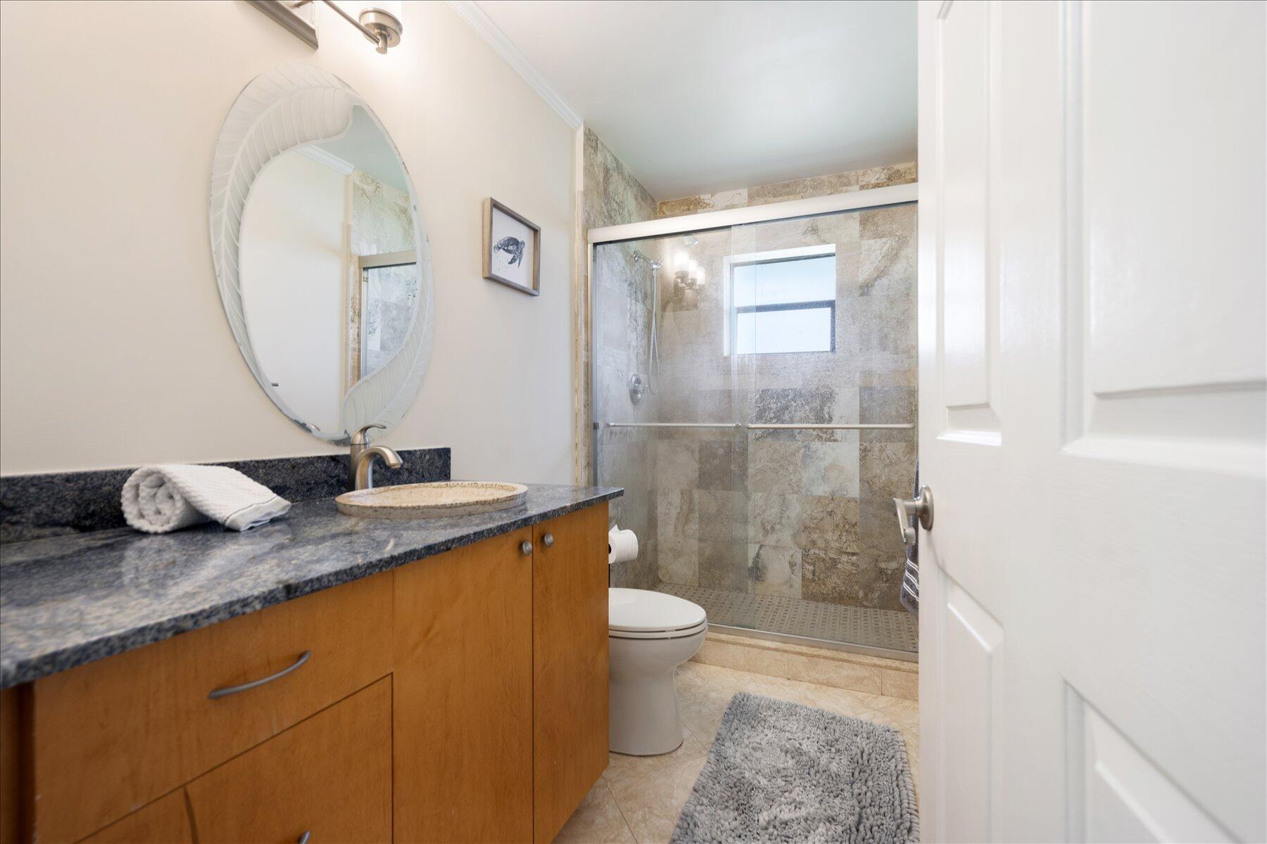 13889 Geranium Place Wellington, FL 33414 - Photo 21 of 32 a bathroom with a granite countertop sink a toilet and a mirror