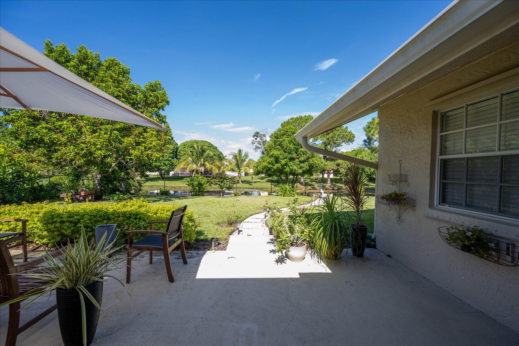 13889 Geranium Place Wellington, FL 33414 - Photo 28 of 32 a view of a lake with a patio