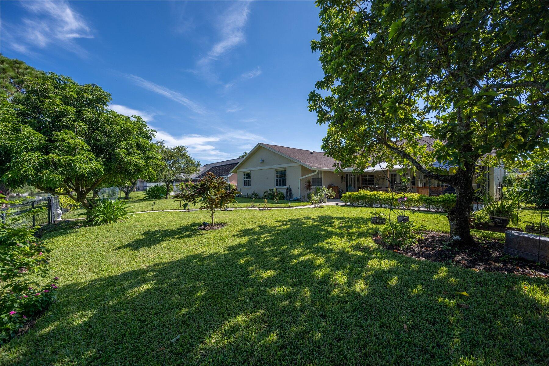 13889 Geranium Place Wellington, FL 33414 - Photo 31 of 32 a front view of a house with a garden