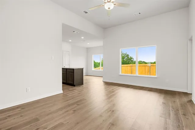 an empty room with wooden floor and a window