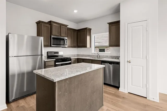 a kitchen with stainless steel appliances granite countertop a refrigerator stove microwave and sink