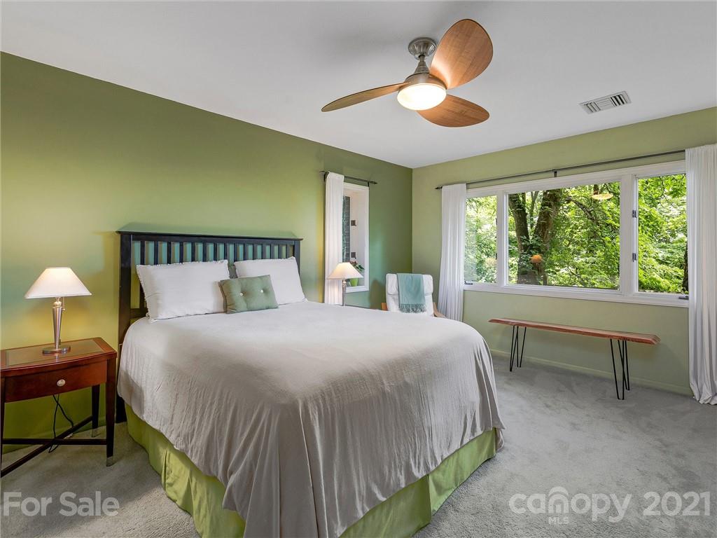 22 Sunset Summit Asheville, NC 28804 - Photo 28 of 42 a bedroom with a bed and a chandelier