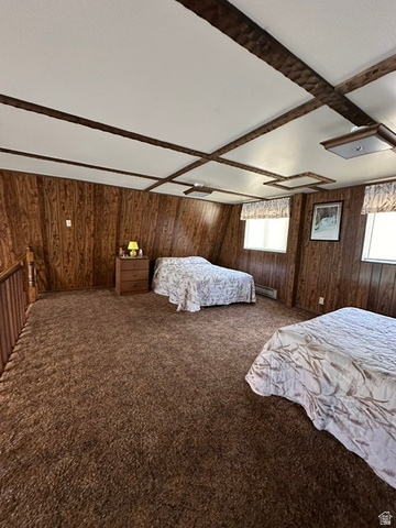 1085 West Elk Road Helper, UT 84526 - Photo 23 of 40 Spacious room featuring wood paneling, a textured ceiling with exposed beams, and soft brown carpeting