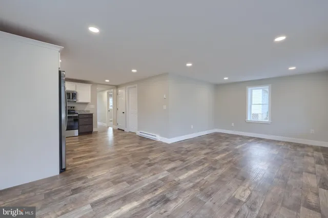 a view of empty room with wooden floor